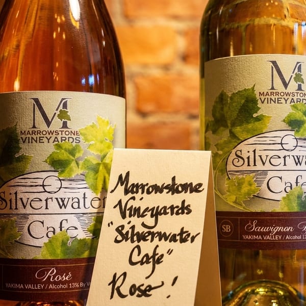 Two bottles of Marrowstone Vineyards "Silverwater Cafe" wine, rosé and Sauvignon Blanc, with a handwritten sign.