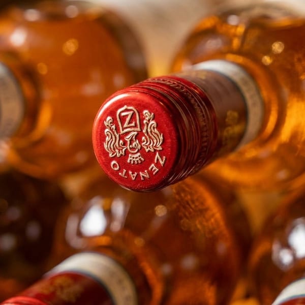 Close-up of Zenato wine bottles with red and gold foil tops, showcasing the brand logo.
